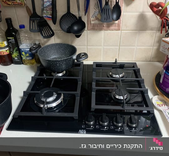 כיריים גז עם סירים וכלי מטבח תלויים